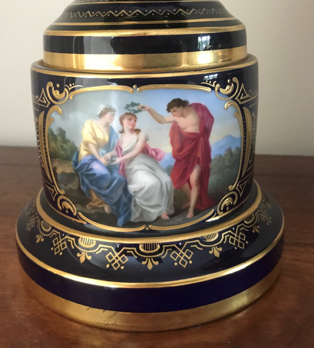 A pair of cobalt blue and gilded Vienna porcelain urns with hand-painted classical mythological figure panels and matching bases. View XI