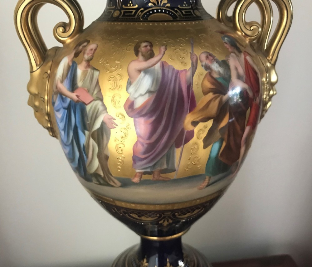 A pair of cobalt blue and gilded Vienna porcelain urns with hand-painted classical mythological figure panels and matching bases. View XII
