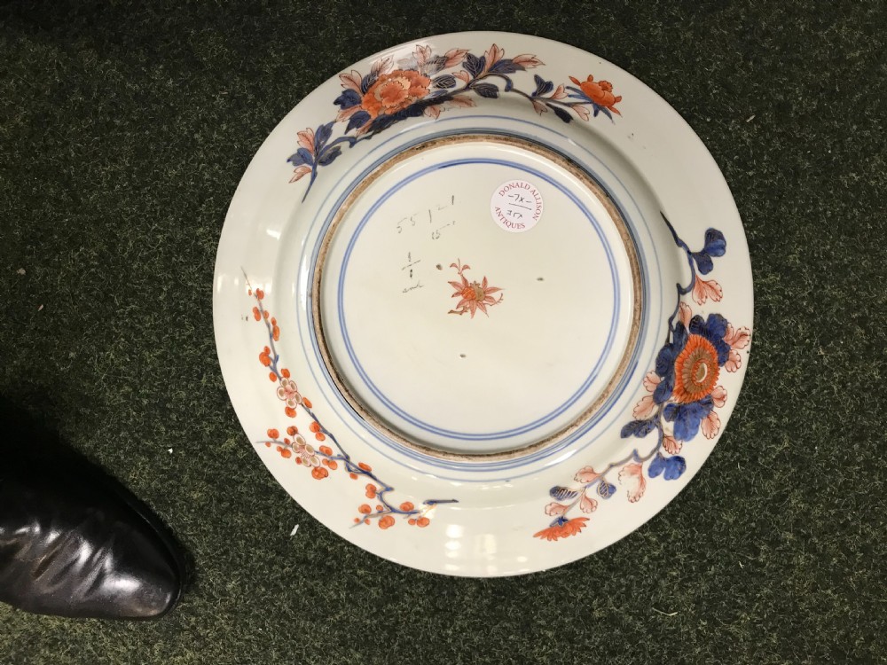 An overhead view of a large round Japanese Imari porcelain charger featuring intricate hand-painted figures, floral motifs, and panels in cobalt blue, iron red, and gold. View V