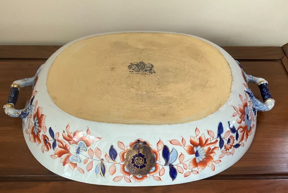 A large oval white ironstone platter and matching pierced strainer insert decorated with dark blue, terracotta, and gold floral Imari patterns. View II