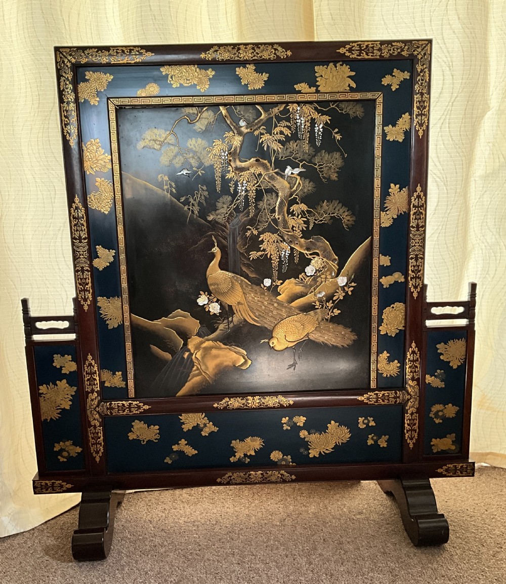 A Japanese single-panel standing screen decorated with gold lacquer peacock and wisteria motifs on a dark background, set within a carved wood frame. View II