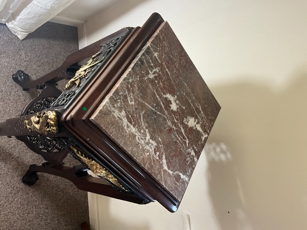 A tall dark wood Japonisme pedestal stand featuring an inset marble top, intricate openwork fretwork, gilt dragon mounts, and carved claw feet. View VI