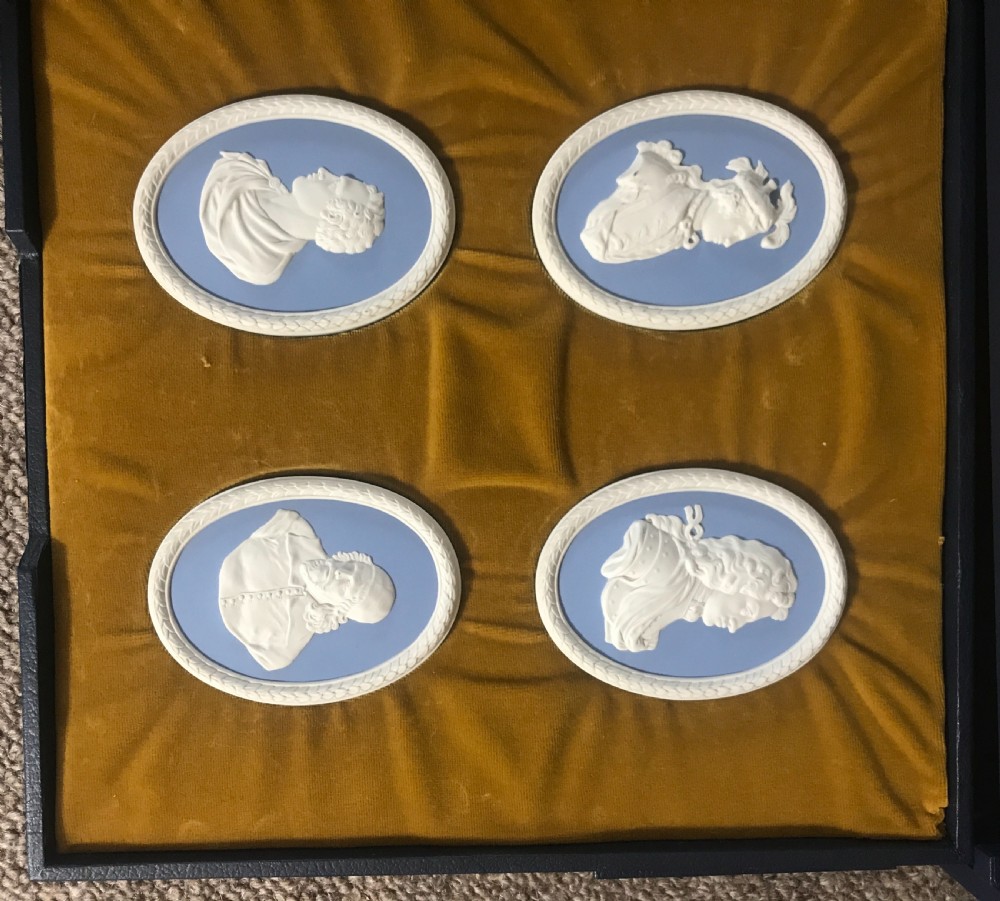 A set of blue and white Wedgwood jasperware oval portrait medallions depicting historical figures, housed in a gold velvet-lined presentation box with drawers. View IV