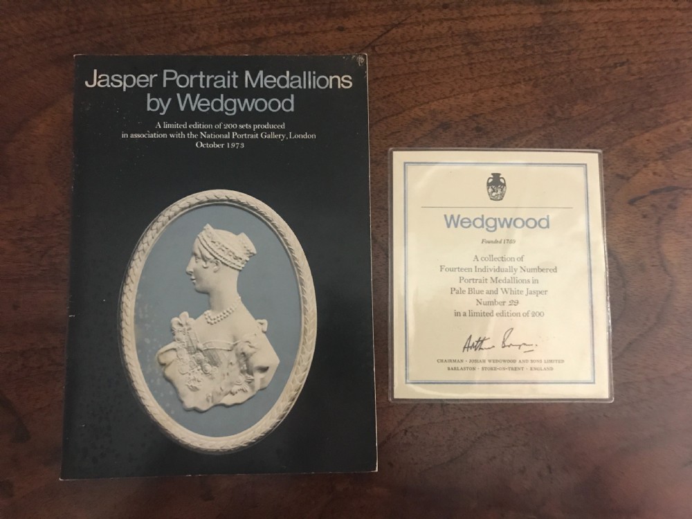 A set of blue and white Wedgwood jasperware oval portrait medallions depicting historical figures, housed in a gold velvet-lined presentation box with drawers. View V