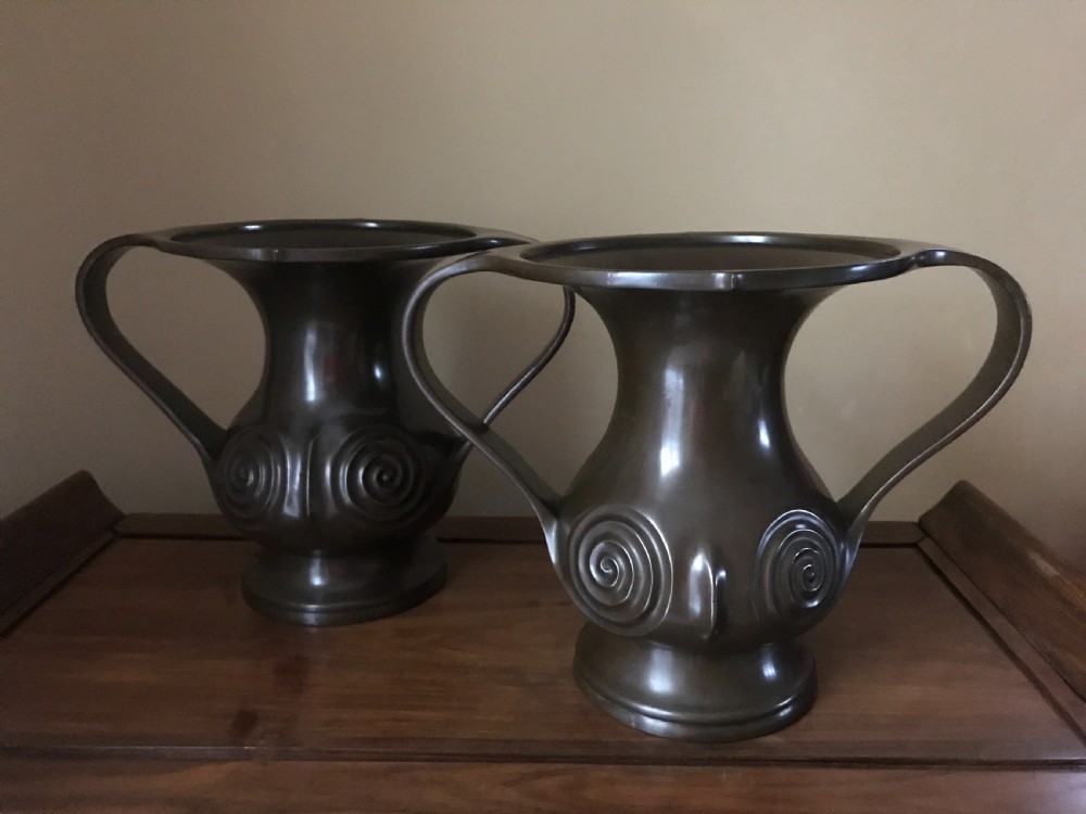A pair of dark brown patinated bronze Japanese Mimikuchi vases featuring wide flaring rims, sweeping side handles, and relief spiral motifs on the body. View III