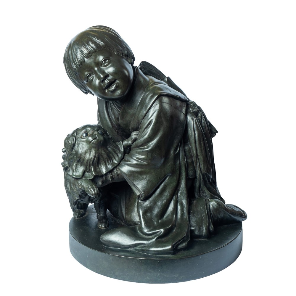 A dark patinated bronze okimono sculpture depicting a kneeling Japanese child in a kimono holding a small Pekingese dog on a rounded base.
