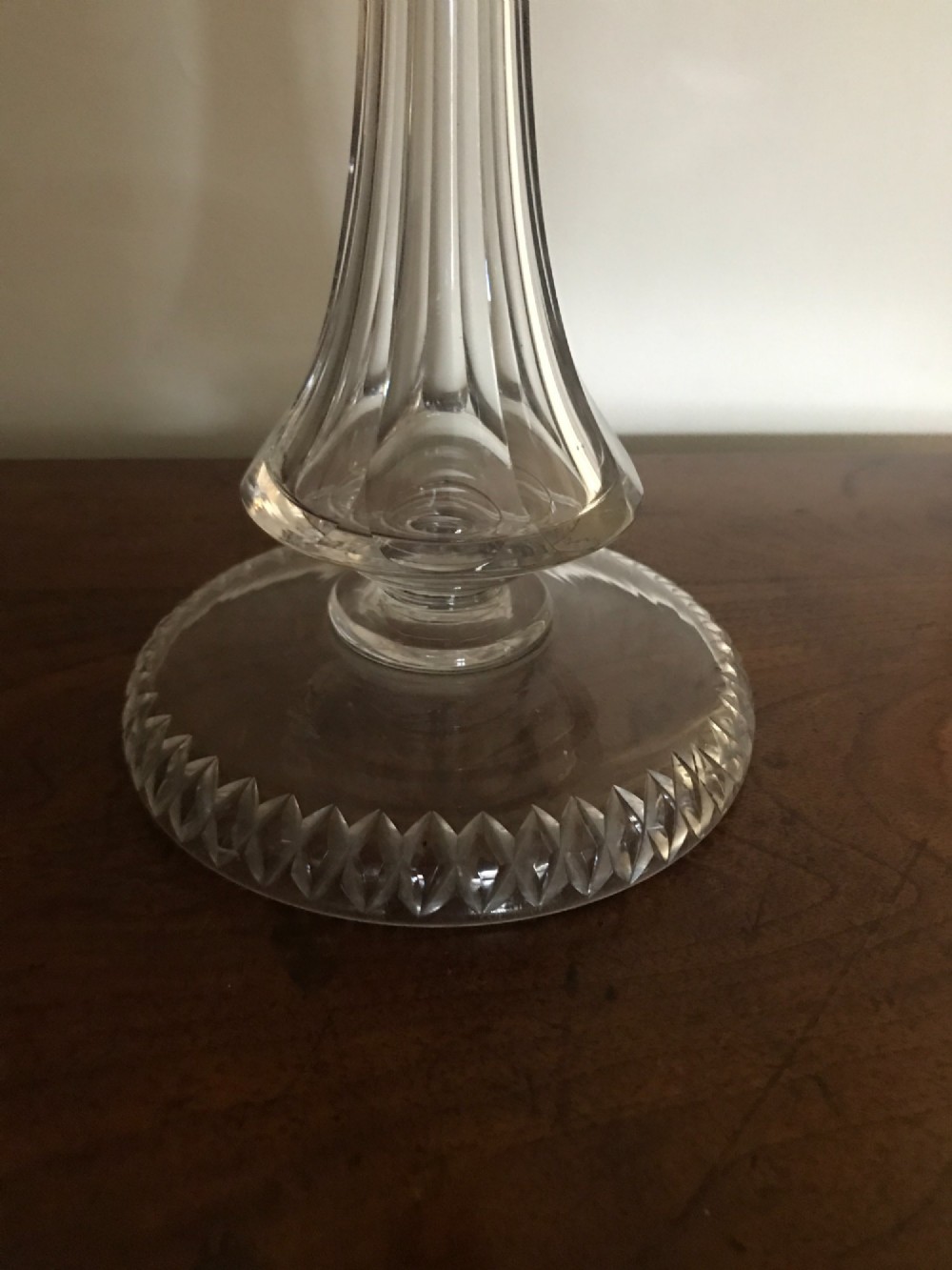 An antique Victorian glass oil lamp featuring a clear fluted crystal stem, rounded glass reservoir, central brass burner, and a tulip shade with a frilled ruby-red rim. View II
