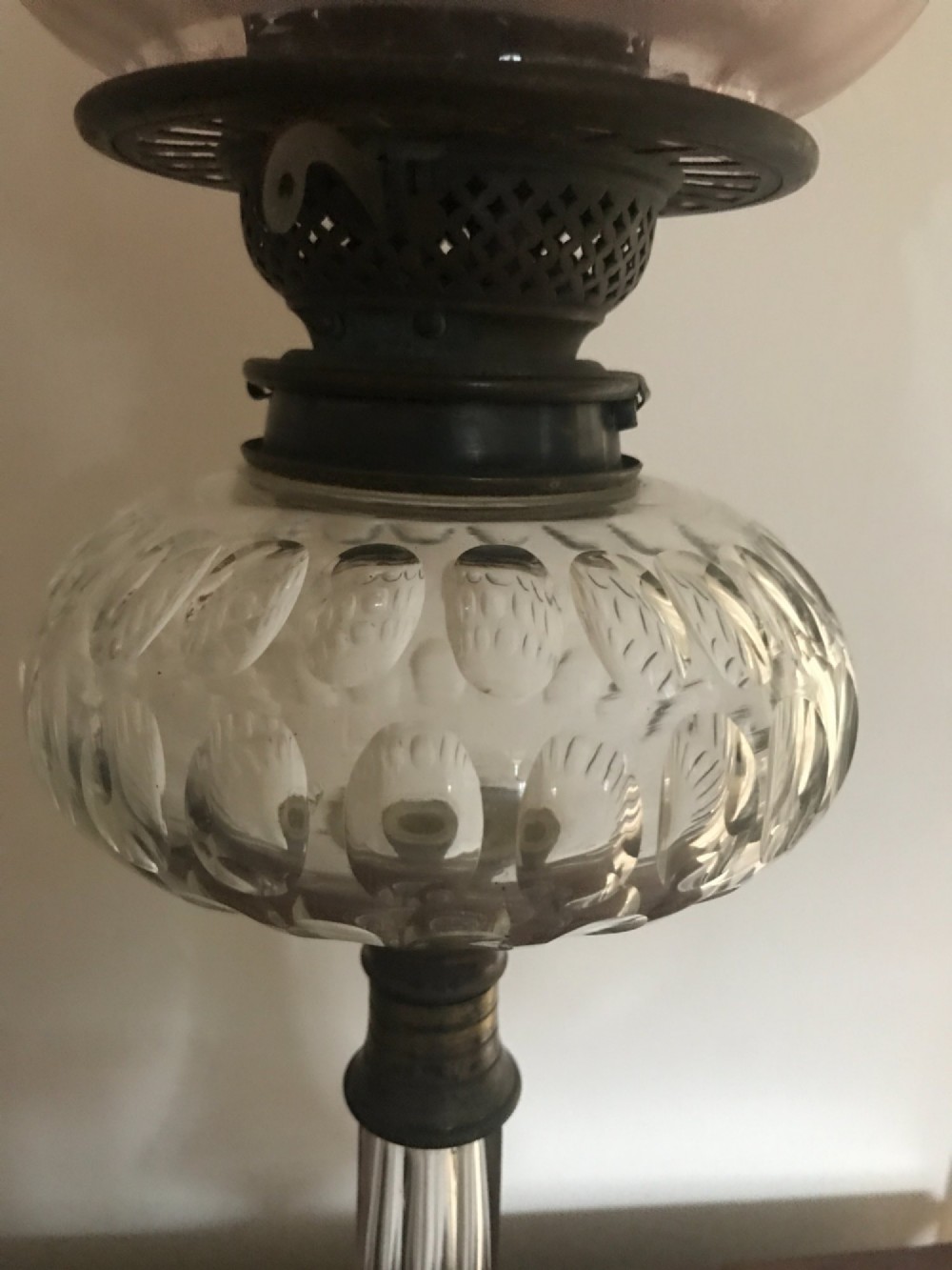 An antique Victorian glass oil lamp featuring a clear fluted crystal stem, rounded glass reservoir, central brass burner, and a tulip shade with a frilled ruby-red rim. View III