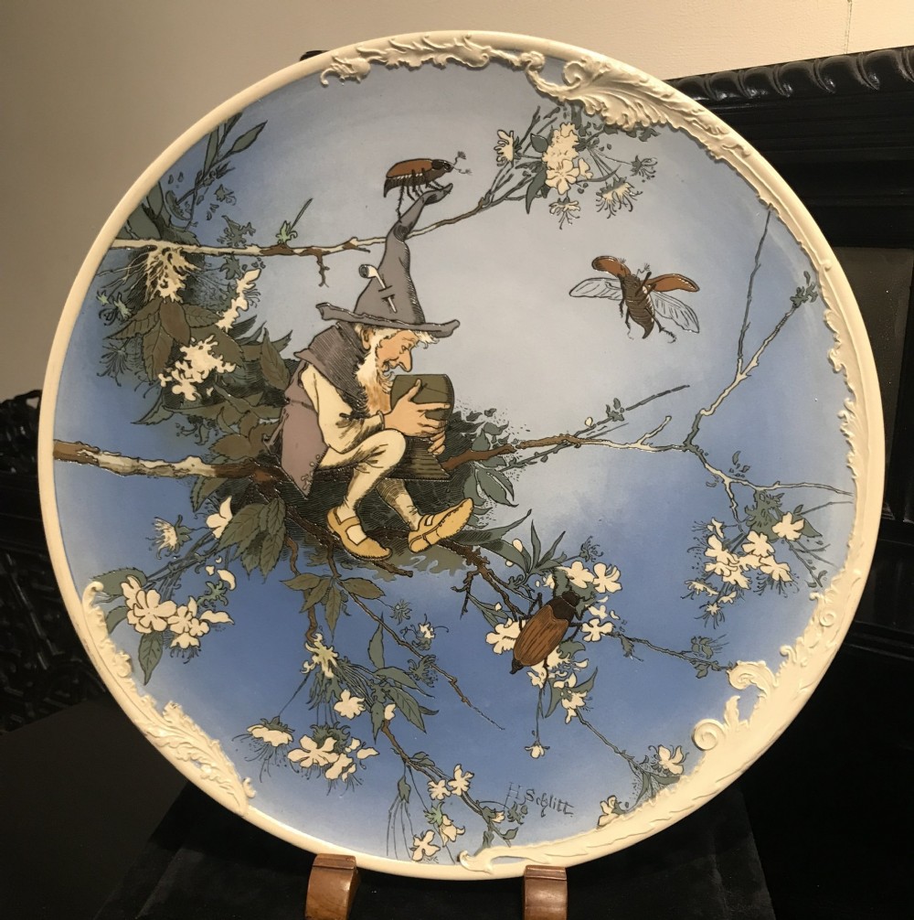 A pair of circular sky blue and cream ceramic wall plaques decorated with illustrations of gnomes and foliage. View III