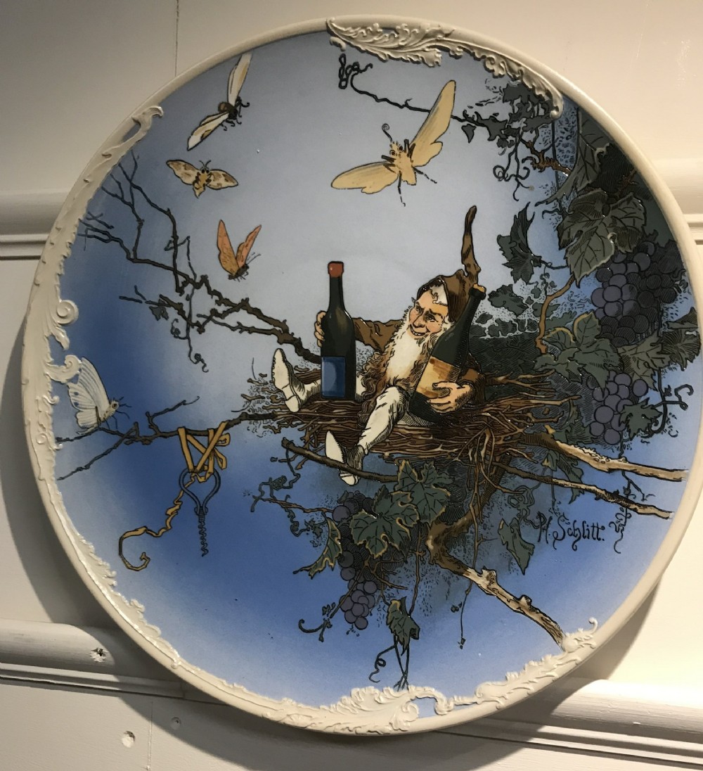 A pair of circular sky blue and cream ceramic wall plaques decorated with illustrations of gnomes and foliage. View IV