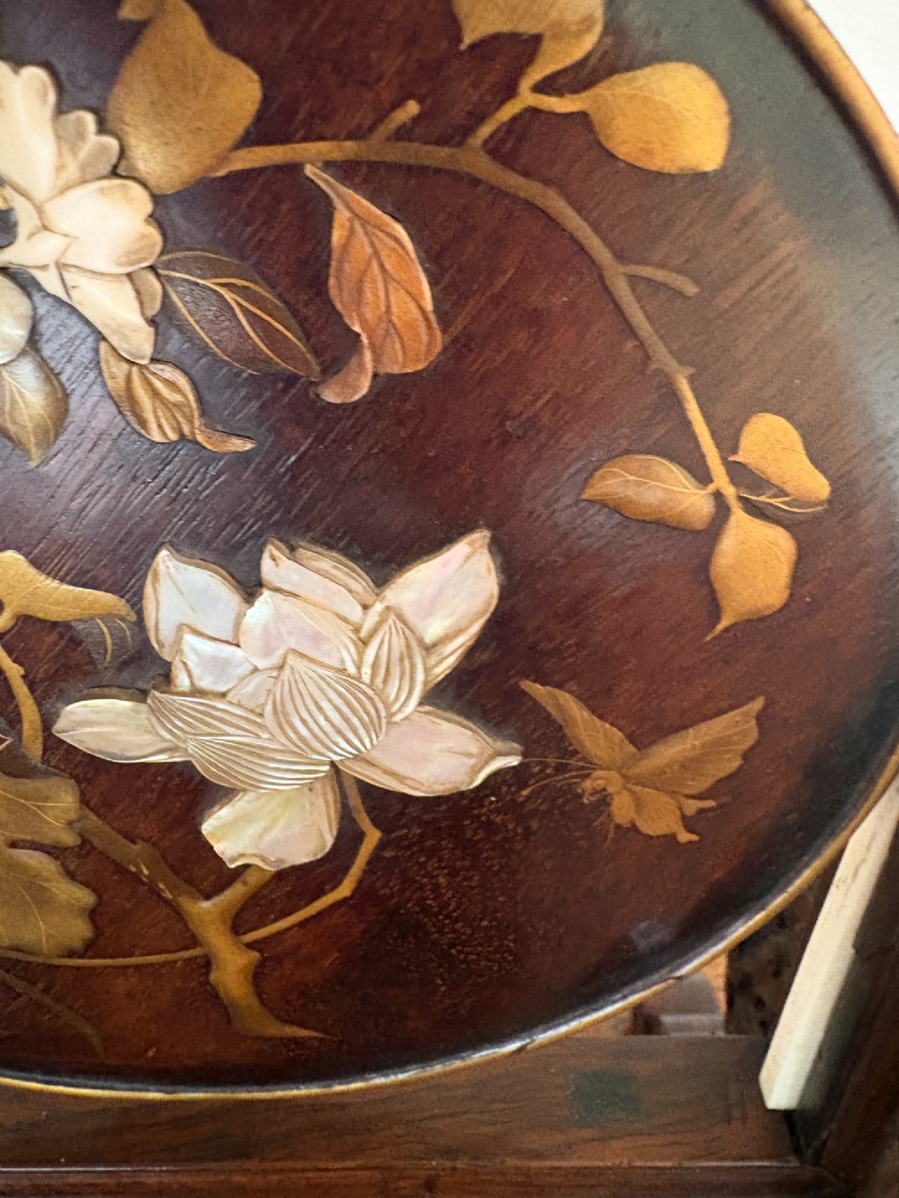 A circular dark wood Japanese table screen featuring raised mother-of-pearl floral and insect inlays, set within a carved hardwood stand. View III