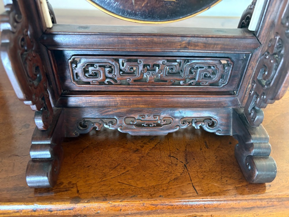 A circular dark wood Japanese table screen featuring raised mother-of-pearl floral and insect inlays, set within a carved hardwood stand. View V