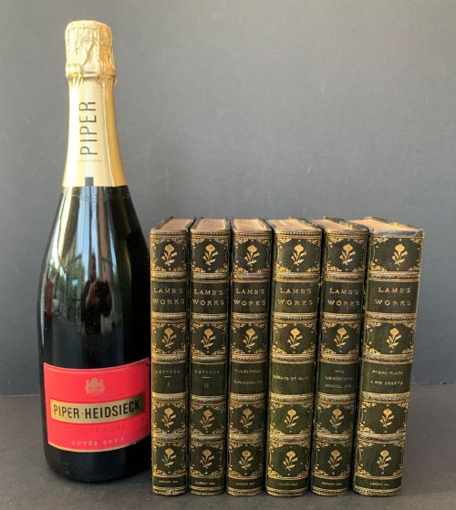 fig 1. A six-volume set of late Victorian books featuring dark green leather spines with gilt floral tooling and title lettering alongside marbled paper boards.