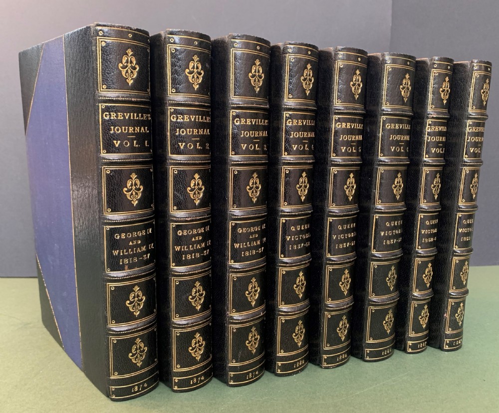 An eight-volume set of 19th-century books bound with dark leather spines, gilt lettering, raised bands, and blue cloth covers.