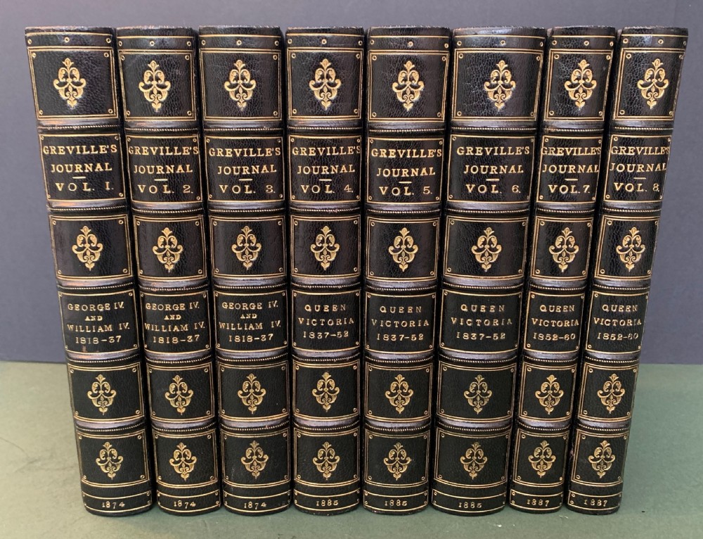 An eight-volume set of 19th-century books bound with dark leather spines, gilt lettering, raised bands, and blue cloth covers. View II