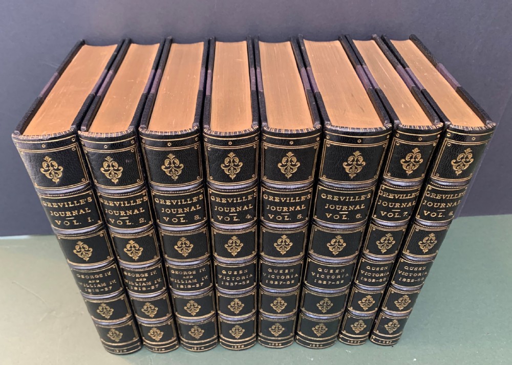 An eight-volume set of 19th-century books bound with dark leather spines, gilt lettering, raised bands, and blue cloth covers. View III