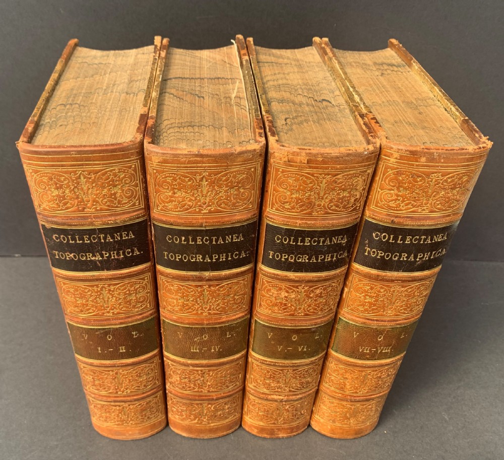 Four antique tan leather-bound volumes with ornate gold gilt decoration and dark title labels on the spines. View III