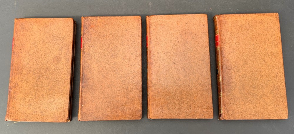 A four-volume set of antique French leather-bound books standing upright, featuring gold gilt tooling and red spine labels numbered one to four. View II