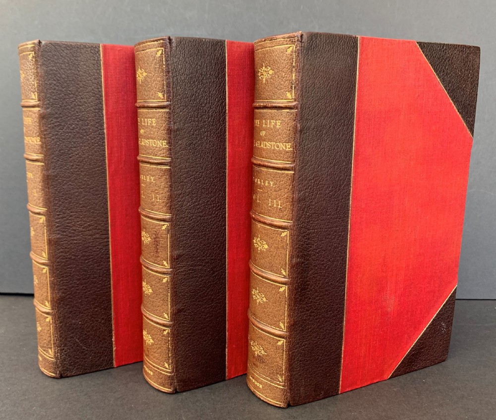 A three-volume set of Edwardian books titled The Life of W E Gladstone, bound in brown half-leather with red cloth sides and gilt spine ornamentation. View VII