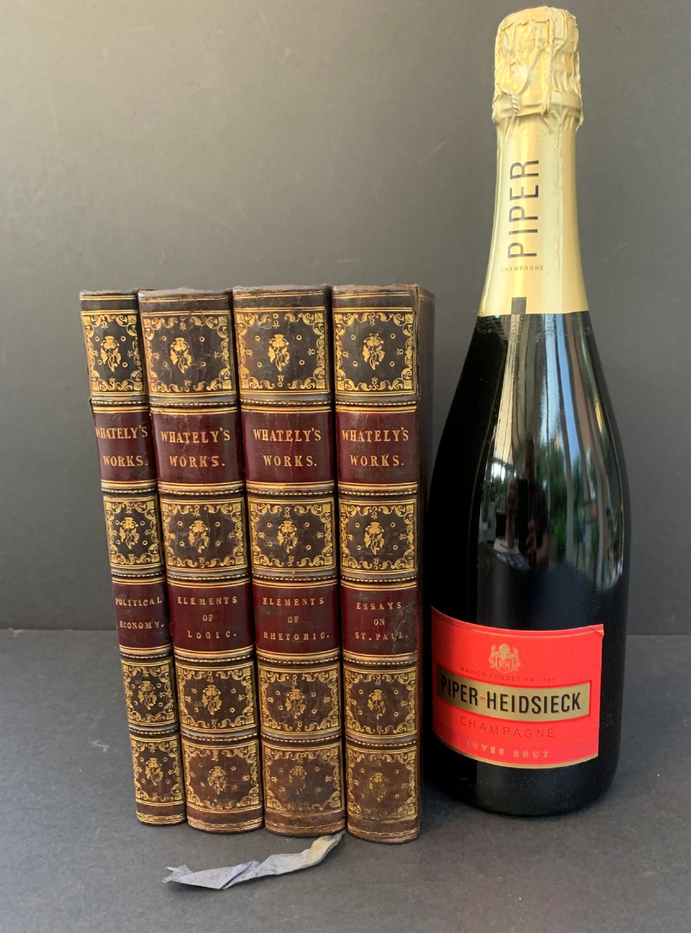 A set of four early 19th-century leather-bound books featuring gilt tooling and titles along their dark reddish-brown spines. View XII