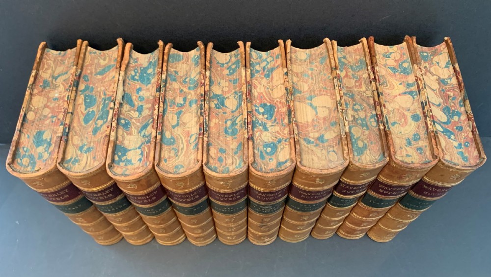 A set of ten Victorian tan leather-bound books titled Waverley Novels displayed side-by-side with gilt tooling and red and green spine labels. View II