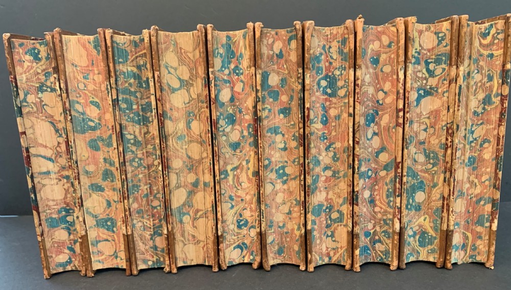 A set of ten Victorian tan leather-bound books titled Waverley Novels displayed side-by-side with gilt tooling and red and green spine labels. View III