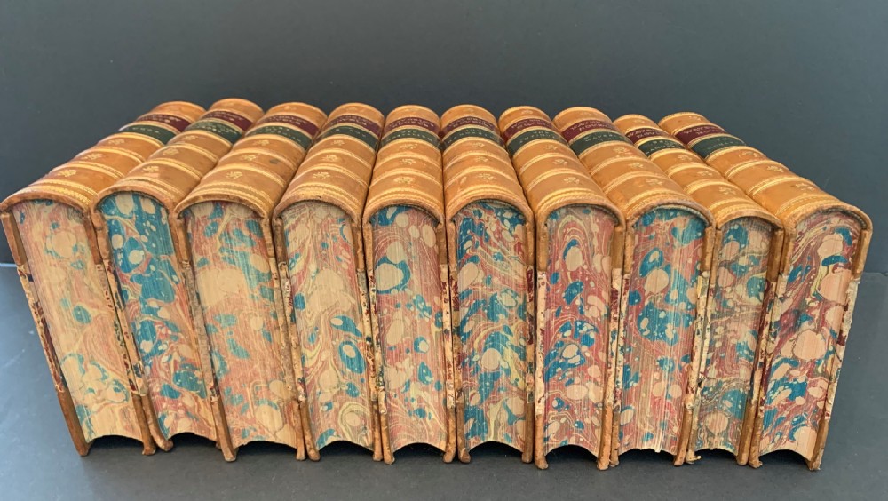 A set of ten Victorian tan leather-bound books titled Waverley Novels displayed side-by-side with gilt tooling and red and green spine labels. View IV