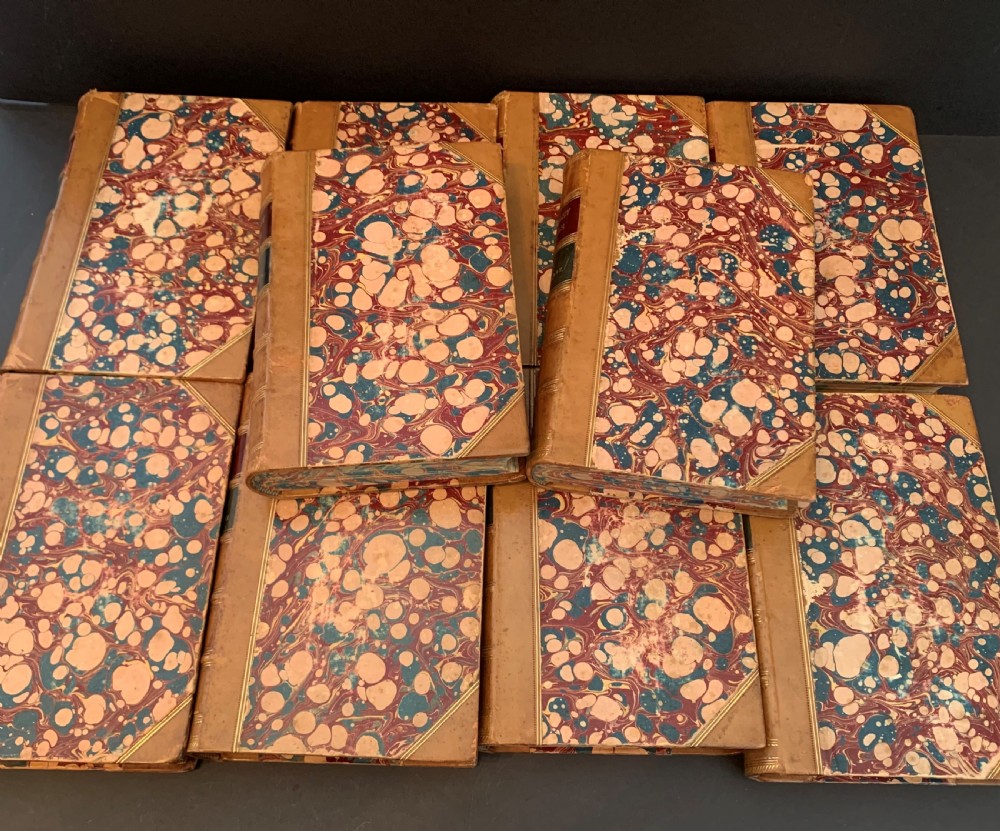 A set of ten Victorian tan leather-bound books titled Waverley Novels displayed side-by-side with gilt tooling and red and green spine labels. View VII