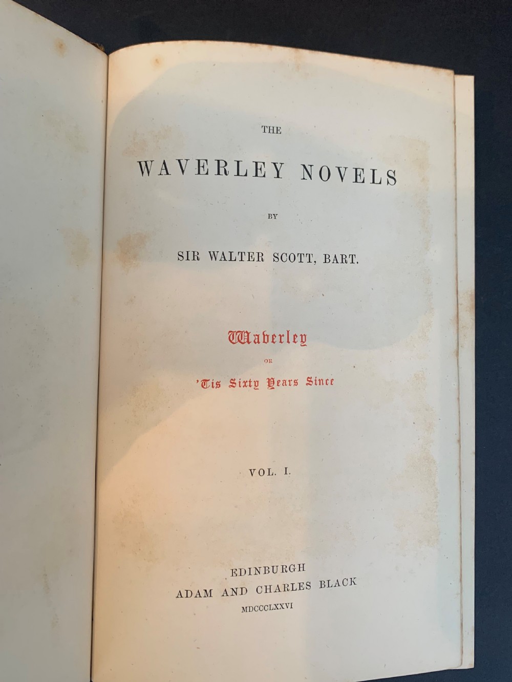 A set of ten Victorian tan leather-bound books titled Waverley Novels displayed side-by-side with gilt tooling and red and green spine labels. View XII