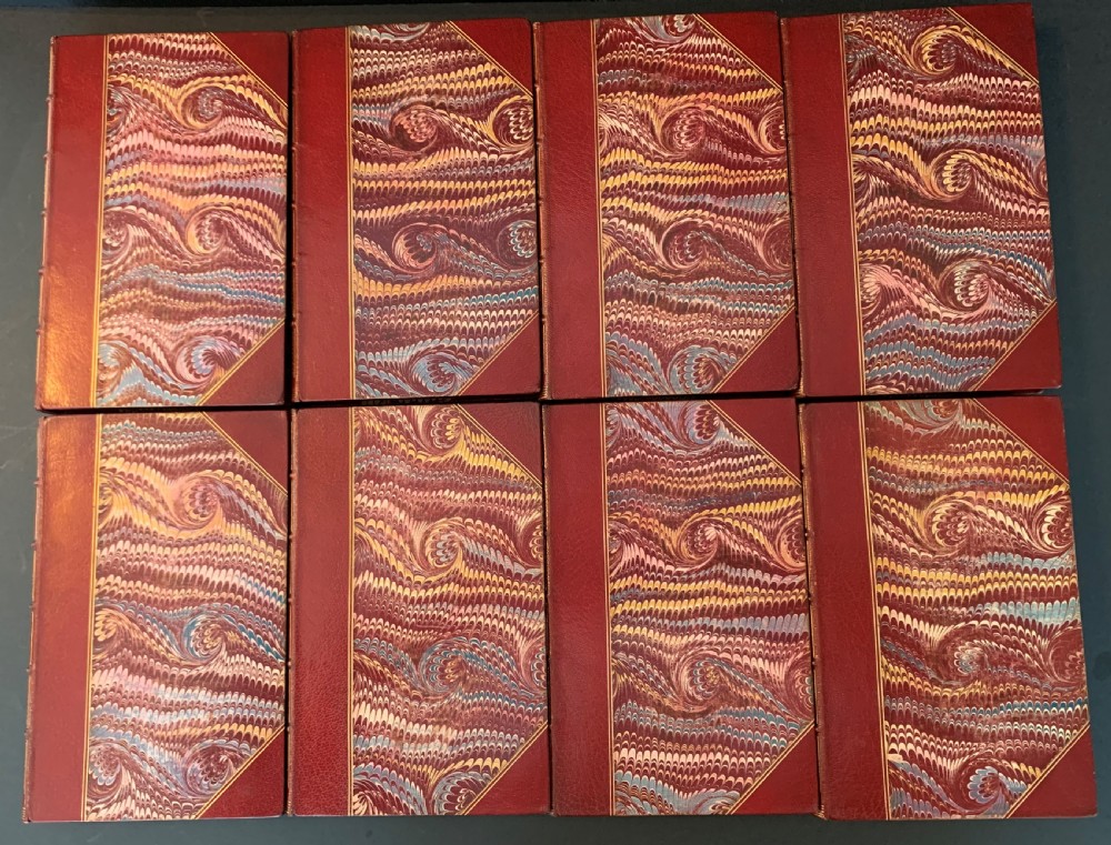 An eight-volume set of 1827 leather-bound books titled Bowdlers Family Shakspeare with red leather spines, raised bands, and gilt decoration. View V