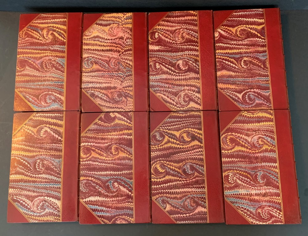 An eight-volume set of 1827 leather-bound books titled Bowdlers Family Shakspeare with red leather spines, raised bands, and gilt decoration. View VI
