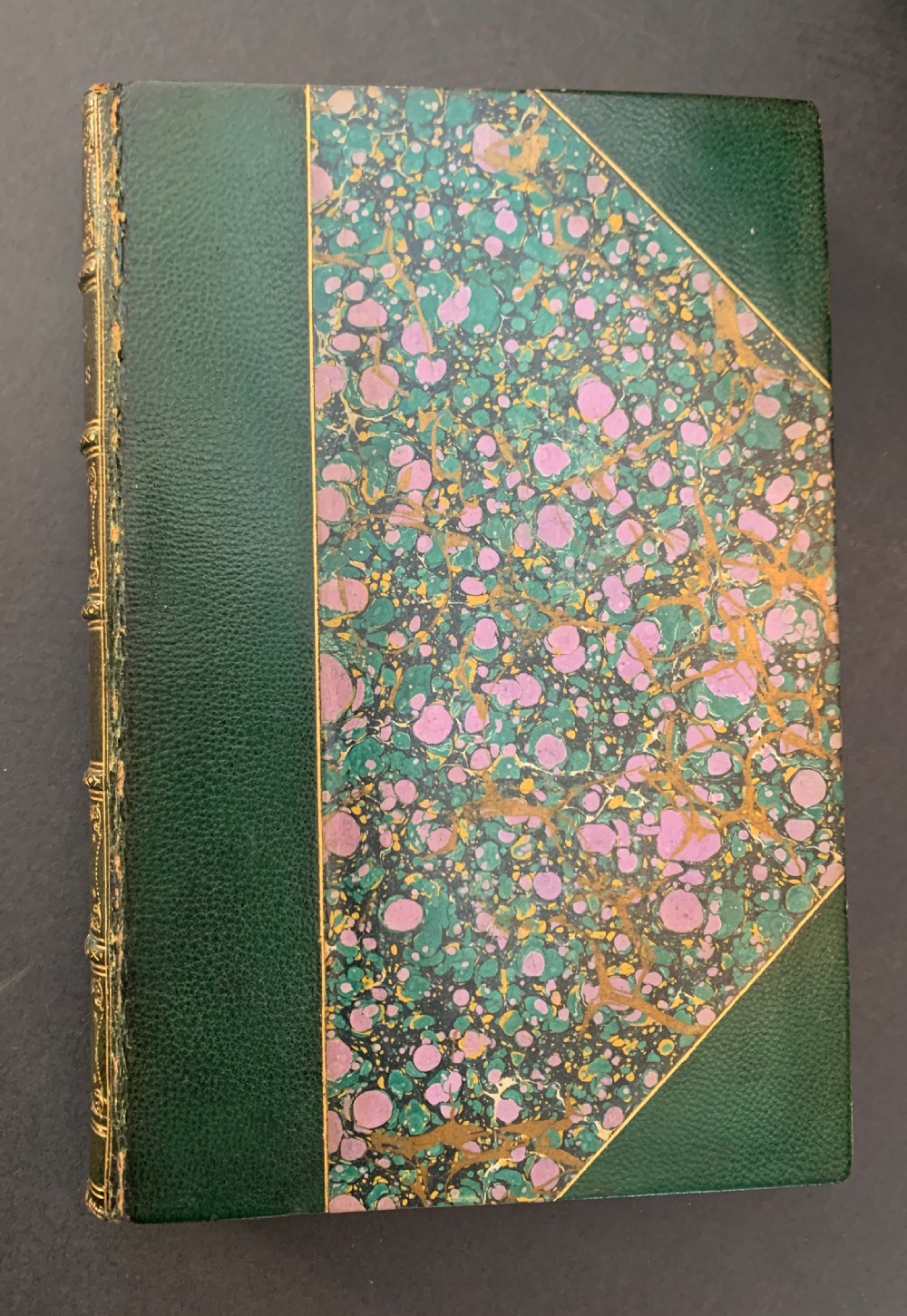 A six-volume set of late Victorian books featuring dark green leather spines with gilt floral tooling and title lettering alongside marbled paper boards. View IV