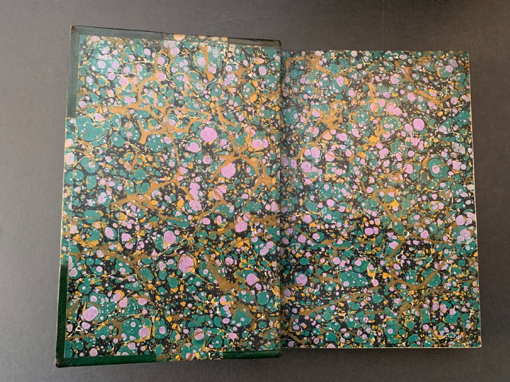 A six-volume set of late Victorian books featuring dark green leather spines with gilt floral tooling and title lettering alongside marbled paper boards. View V