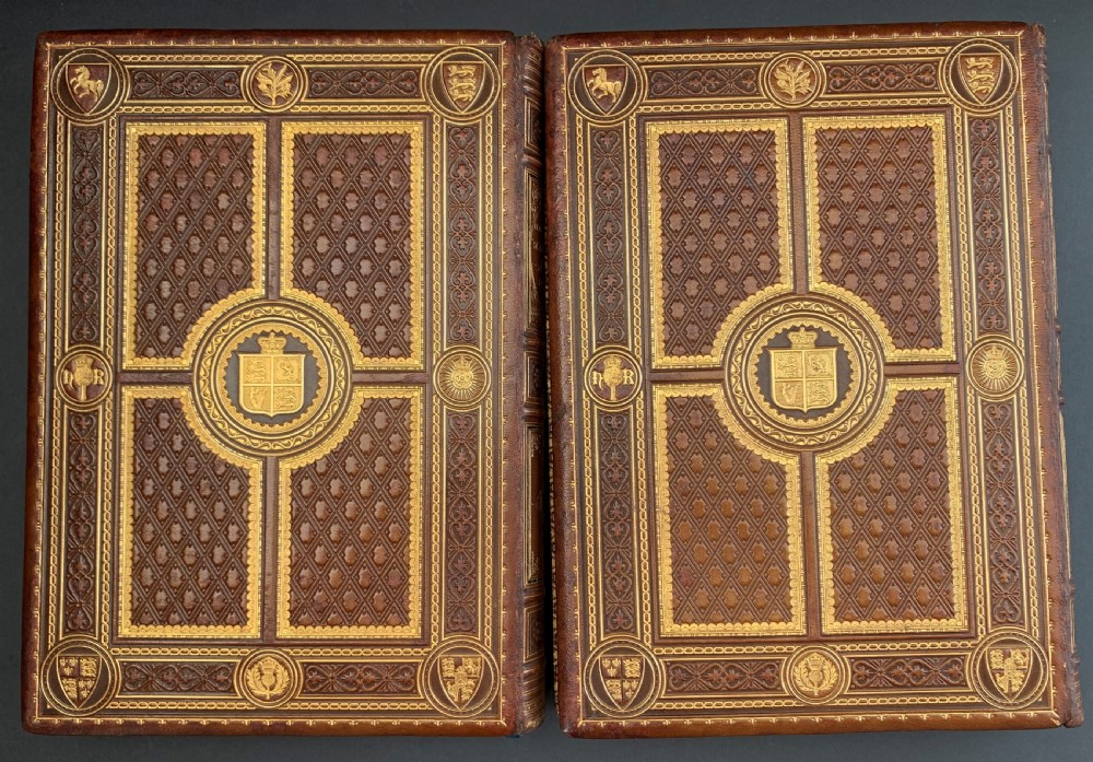 A pair of Victorian leather-bound books featuring gold leaf tooling, crest motifs, and embossed geometric patterns on the brown boards and spines. View IV