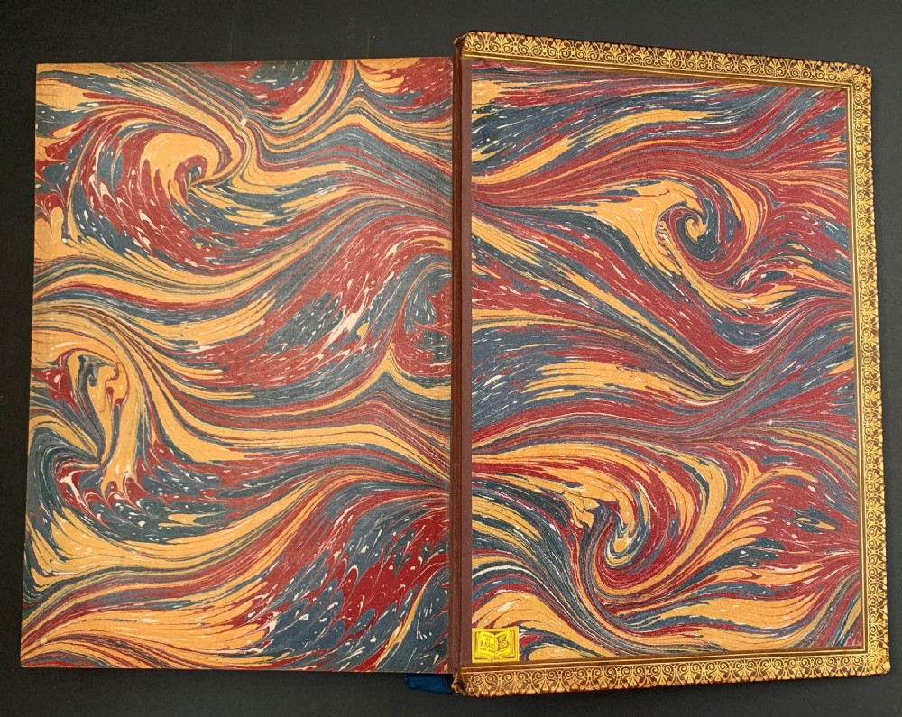 A pair of Victorian leather-bound books featuring gold leaf tooling, crest motifs, and embossed geometric patterns on the brown boards and spines. View VII