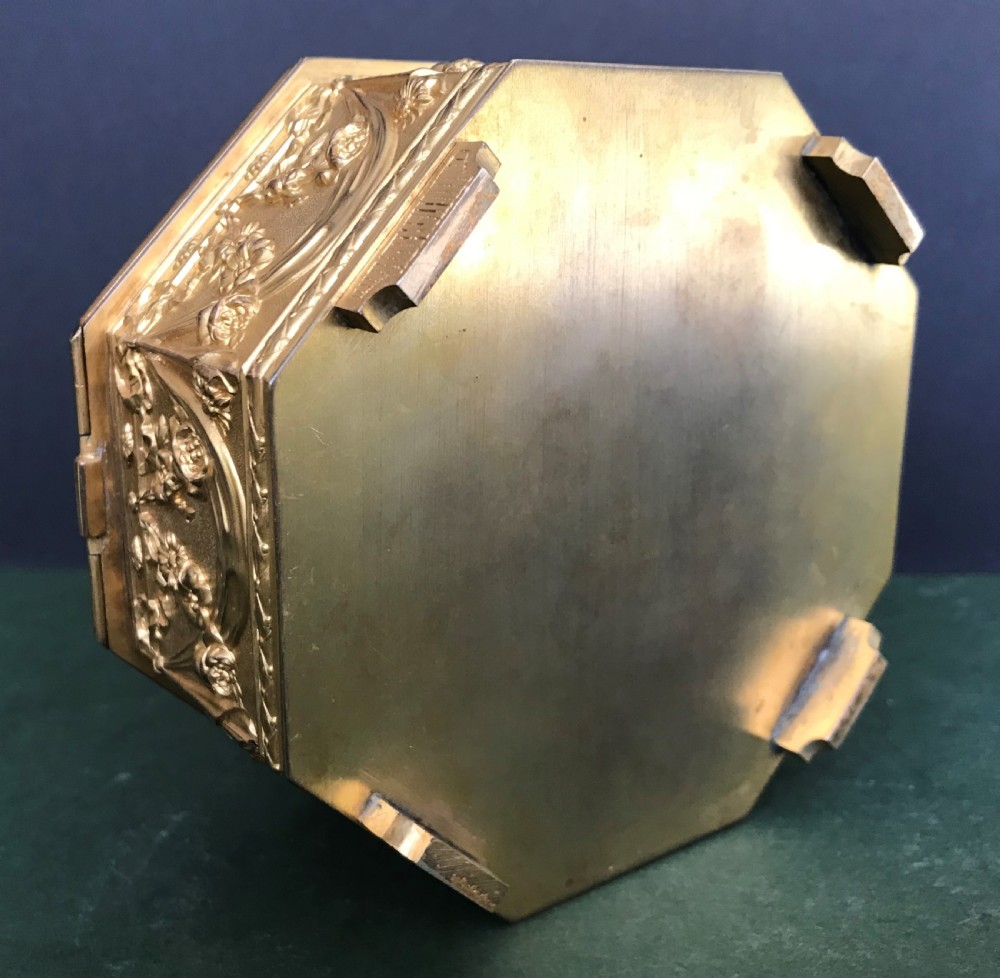 An octagonal French gilded copper jewellery casket decorated with detailed relief carvings of cherubs and floral garlands. View IV