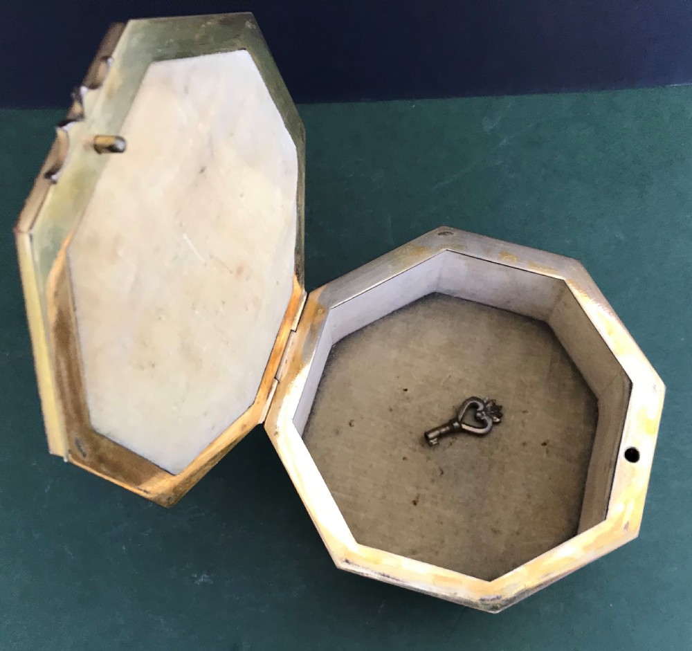An octagonal French gilded copper jewellery casket decorated with detailed relief carvings of cherubs and floral garlands. View VIII