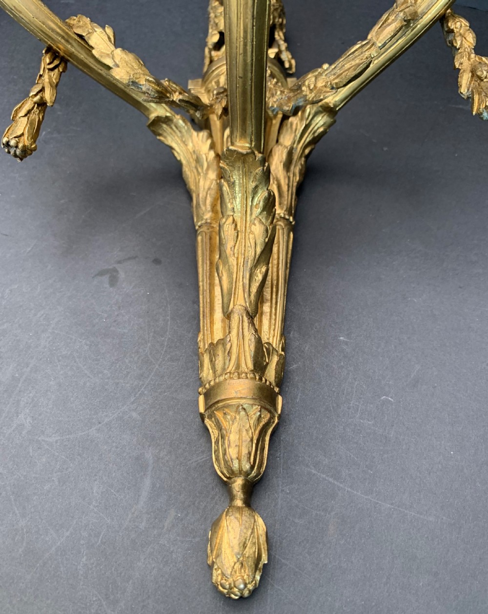 A pair of French gilt bronze wall lights featuring three curving candle branches decorated with leaf swags and topped with urn backplates. View VI