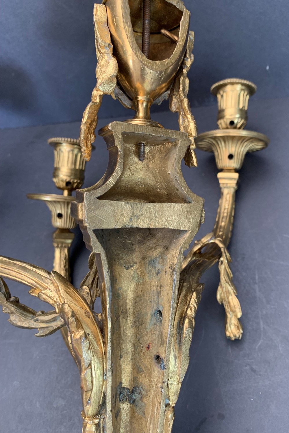 A pair of French gilt bronze wall lights featuring three curving candle branches decorated with leaf swags and topped with urn backplates. View XI