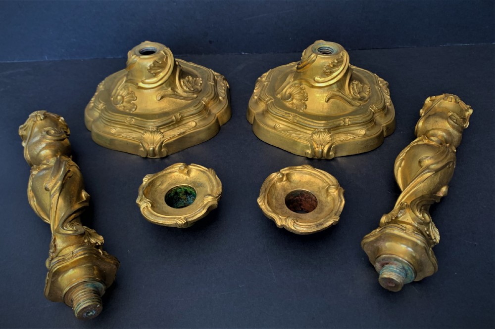 A pair of 19th-century French ormolu candlesticks featuring intricate acanthus leaf carving, rocaille shell motifs, and a gilded finish. View VII