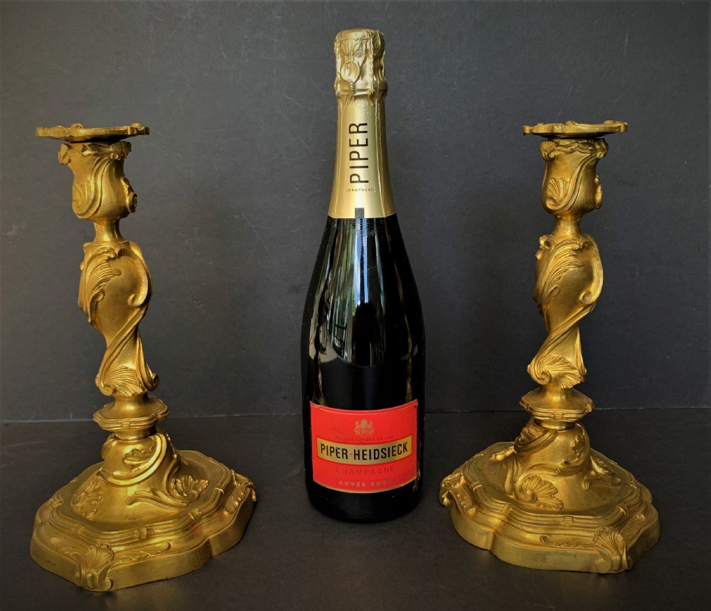 A pair of 19th-century French ormolu candlesticks featuring intricate acanthus leaf carving, rocaille shell motifs, and a gilded finish. View XI