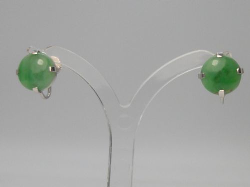 fig 1. Pair of round green jadeite cabochon earrings set in four-prong white gold mounts with screw-back fittings.