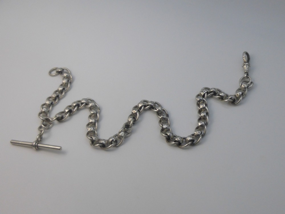 A Victorian sterling silver Albert pocket watch chain featuring heavy curb links, a T-bar fastener, and a swivel clasp.