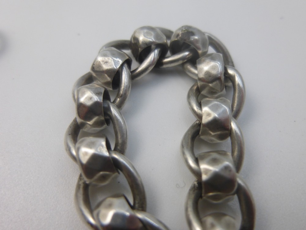 A Victorian sterling silver Albert pocket watch chain featuring heavy curb links, a T-bar fastener, and a swivel clasp. View VI