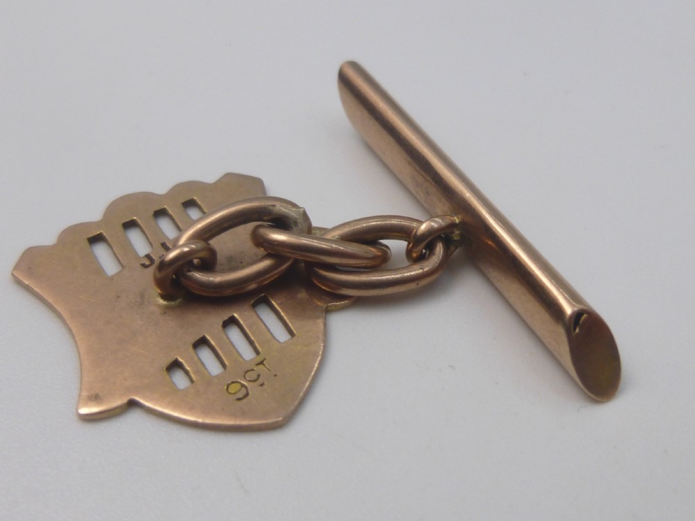 A pair of Edwardian 9ct rose gold cufflinks featuring pierced shield-shaped faces linked to torpedo backs. View III