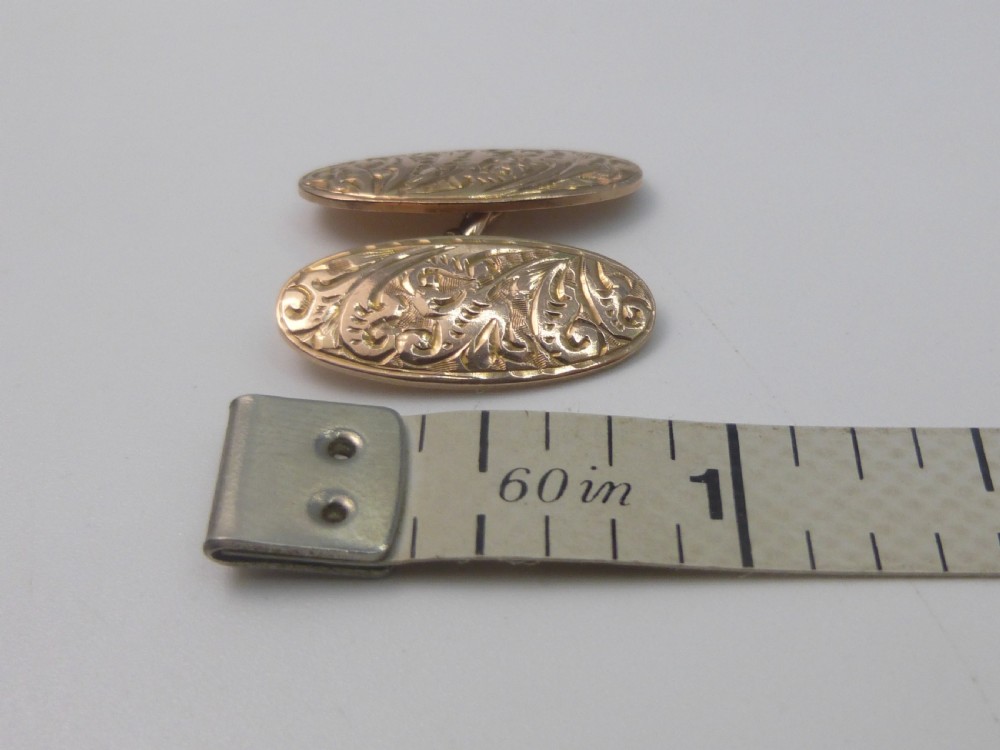 A set of four Edwardian nine-carat rose gold oval cufflink faces with hand-engraved scrollwork motifs. View III
