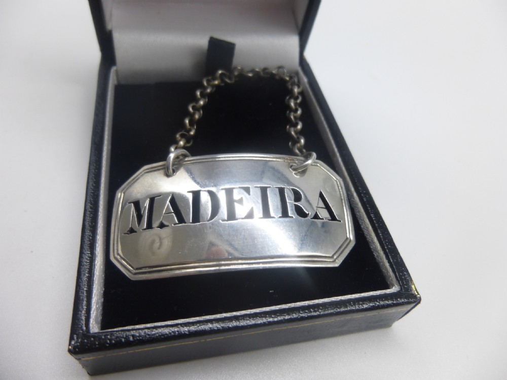 A rectangular William IV sterling silver decanter label with clipped corners engraved with the word Madeira and attached to a silver link chain. View XII