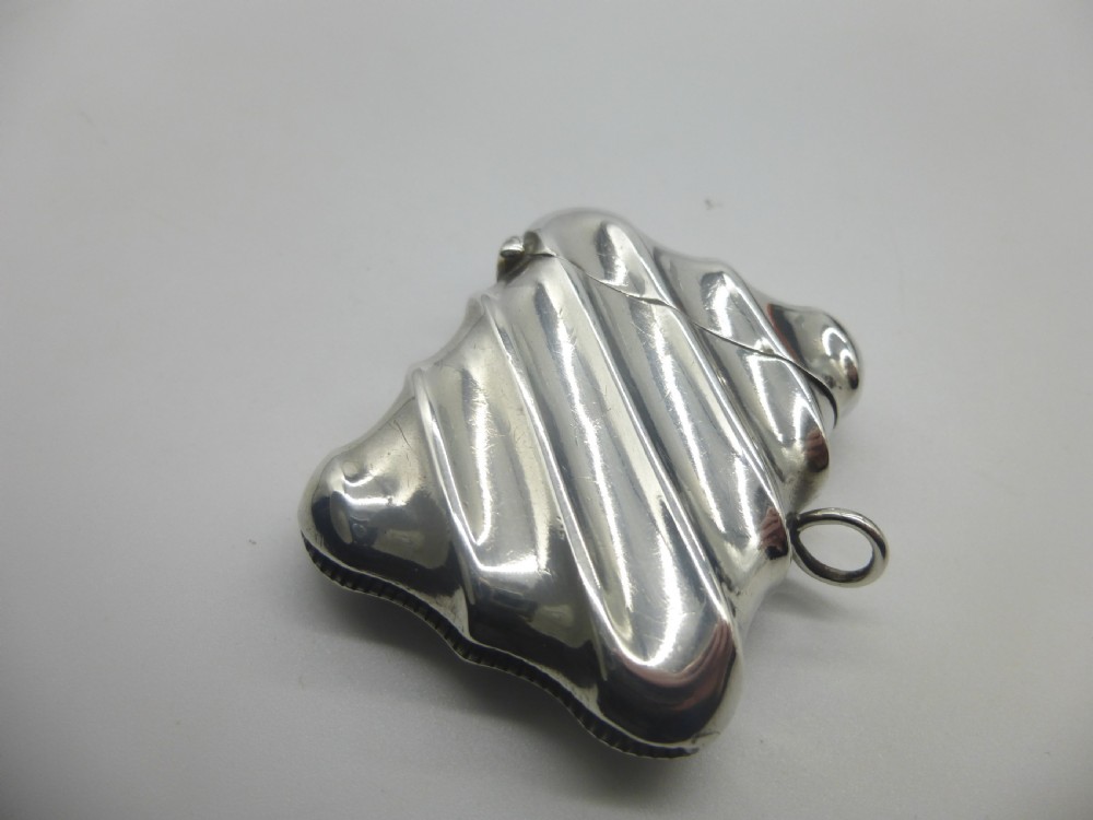 A Victorian silver vesta case featuring a diagonal fluted design, hinged lid, and side suspension ring.