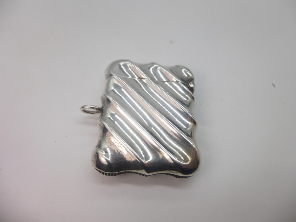 A Victorian silver vesta case featuring a diagonal fluted design, hinged lid, and side suspension ring. View VI
