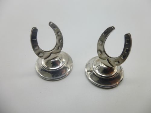 A pair of sterling silver horseshoe menu card holders